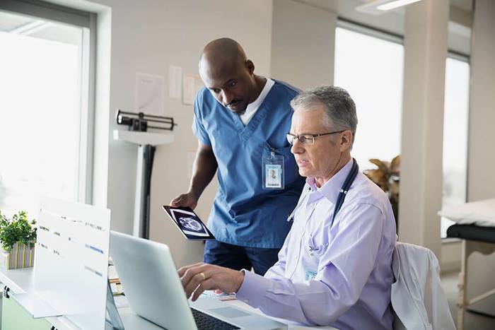 Medical professionals reviewing information on computer