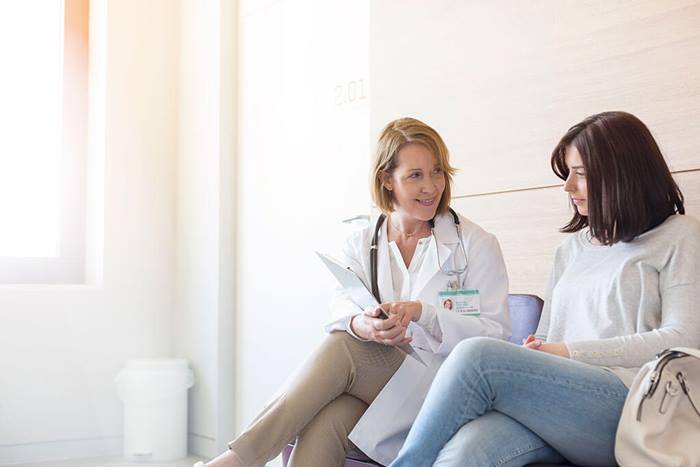 Doctor reviewing information on clipboard with patient