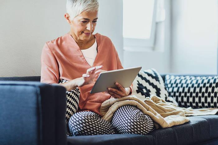 woman using tablet on sofa