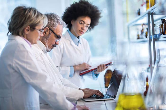 Doctors analyzing data on laptop