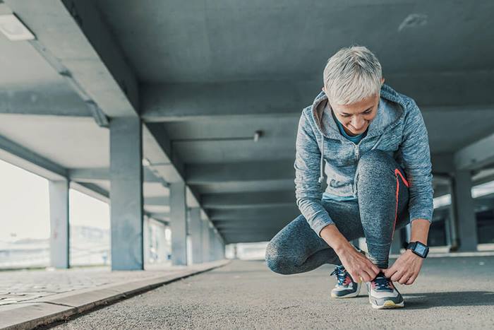 active senior woman tying her shoes