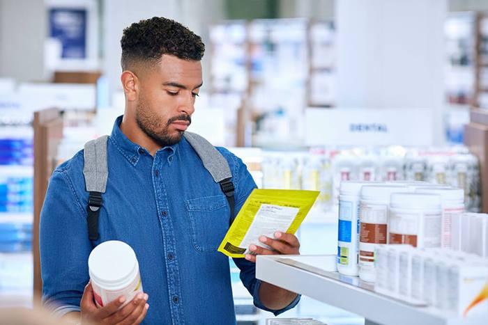 male pharmacy customer comparing nutritional products