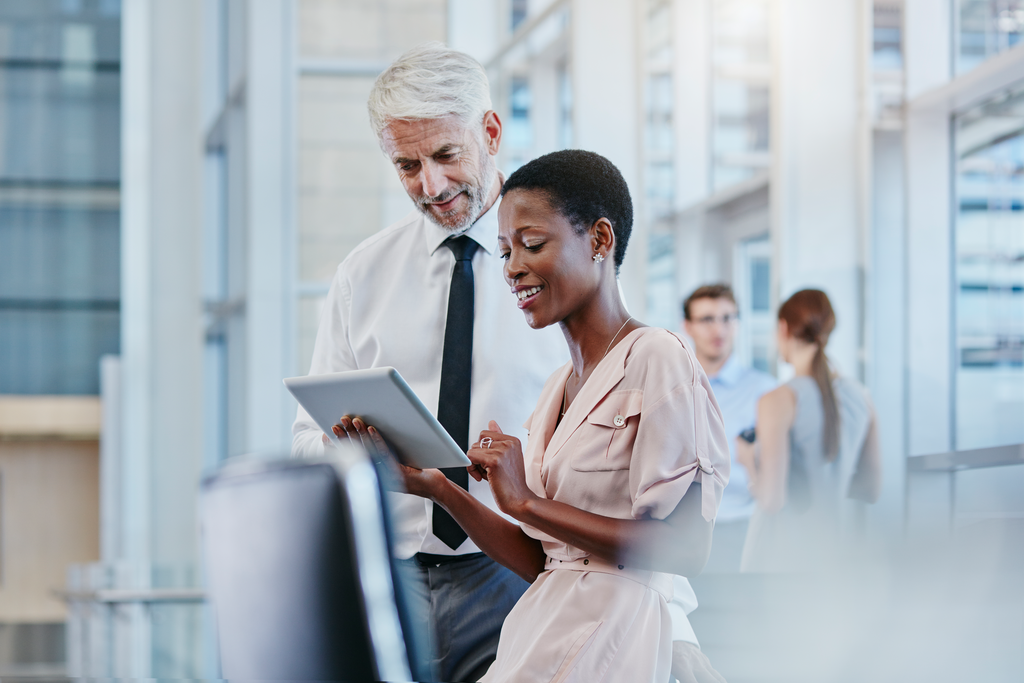 Businessman and Businesswoman looking at tablet