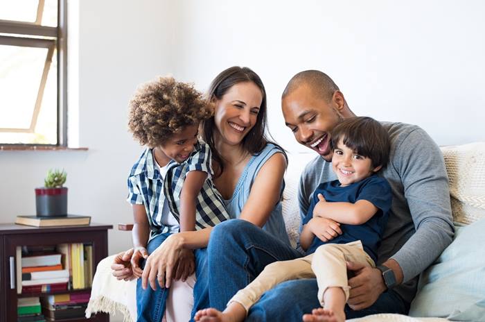 -Family sitting together on couch laughing