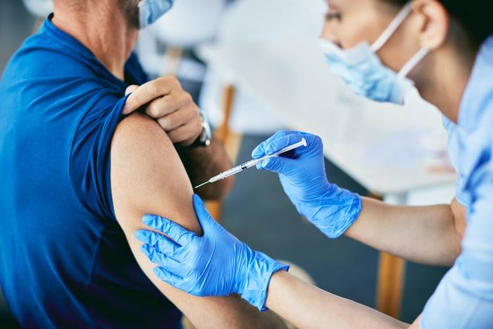 Close-up of nurse vaccinating a man against coronavirus at medical clinic