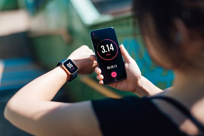 Woman exercising using phone and smart watch