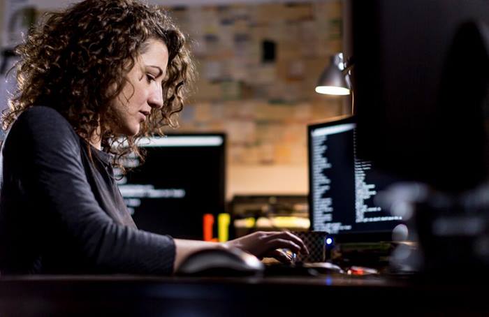 female student typing a mail in her home office