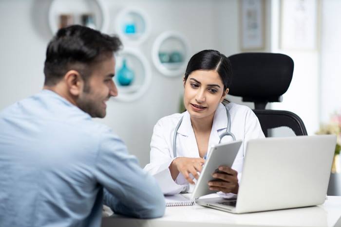 Uses laptop while talking with patient