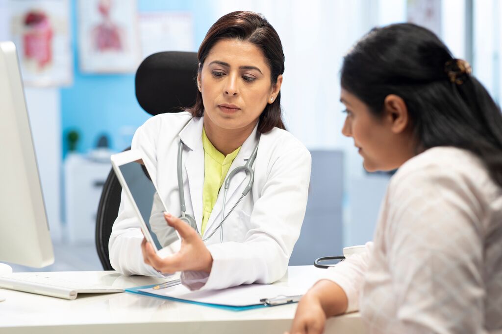 Doctor and patient are discussing at clinic showing report