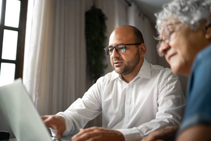 Advisor helping a senior woman at home or mother and son