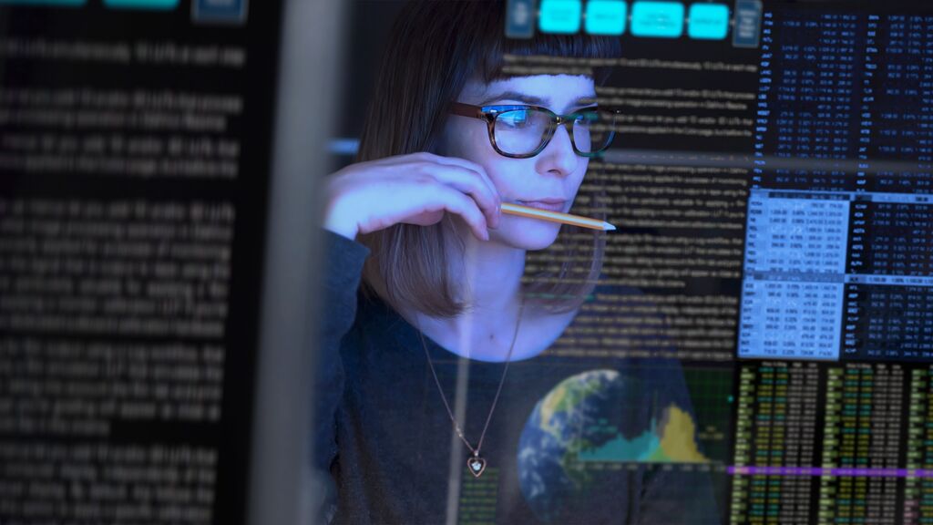Young woman analyzing data on a transparent computer screen, ensuring comprehensive compliance with cloud-based solutions and efficient field recall management.