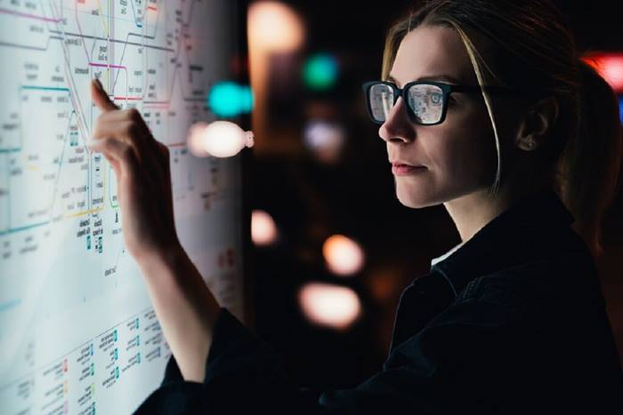 Young woman touching big digital monitor