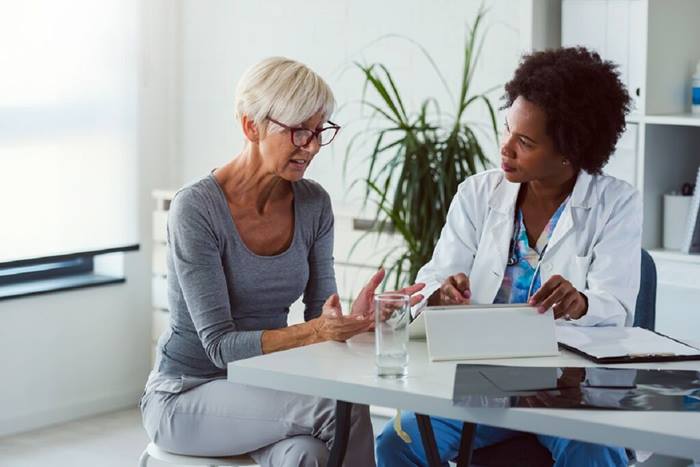 Female doctor with elderly female patient looking at test results