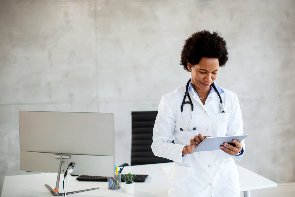 Female doctor standing looking at digital tablet