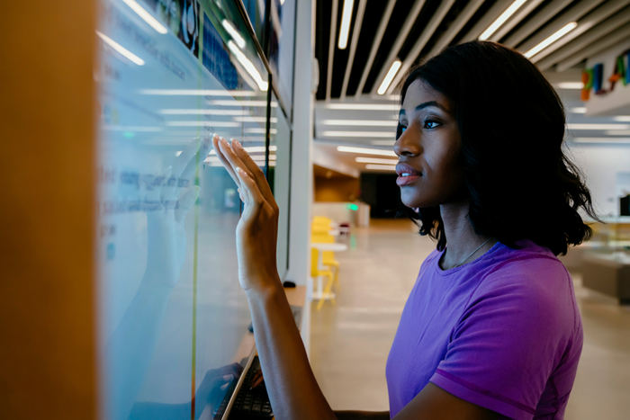 Woman touching large screen monitor