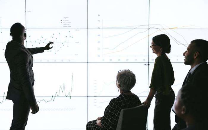 Silhouettes of business man giving presentation to group
