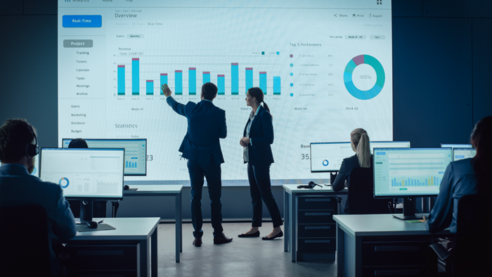 Meeting in modern monitoring office with analytics on a big digital scr