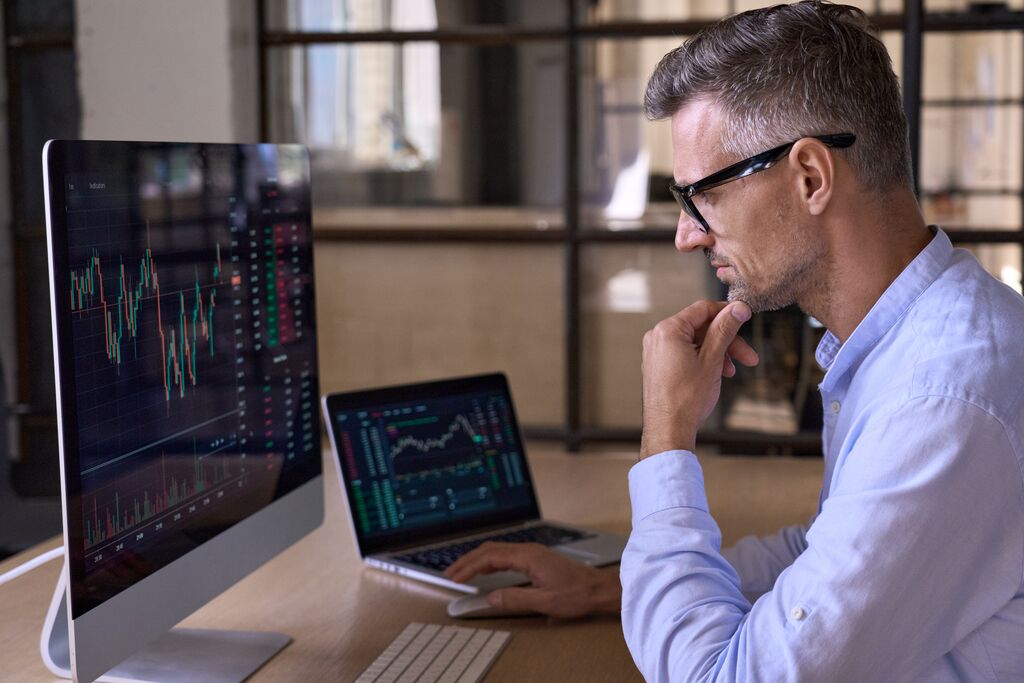 Investor analyzing charts graphs thinking of investing and risks