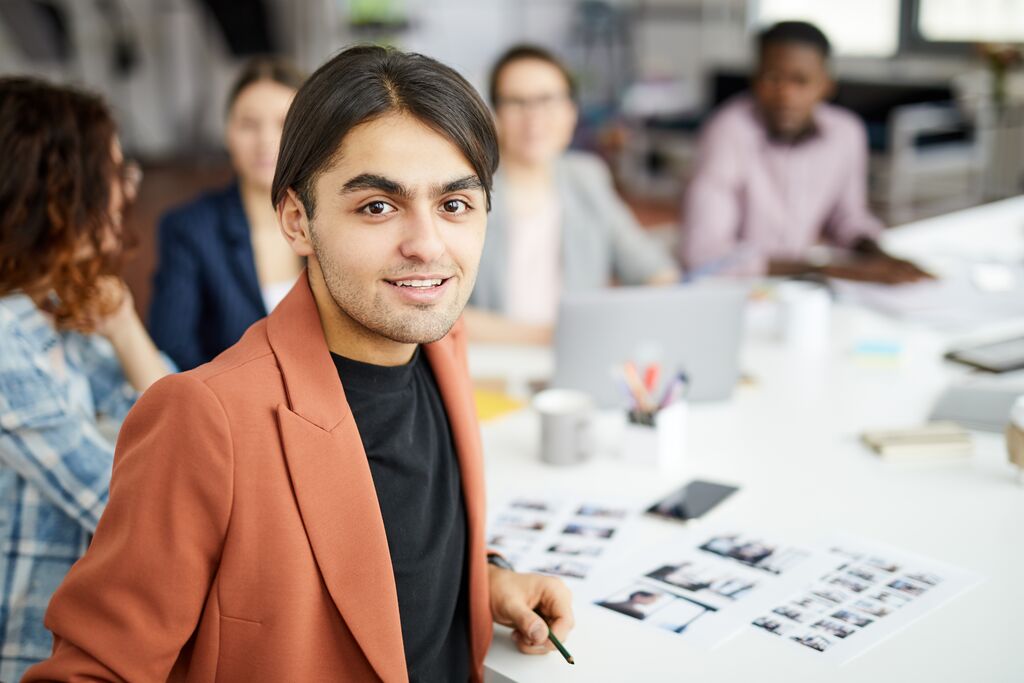 Man looking at camera sitting at table during business meeting
