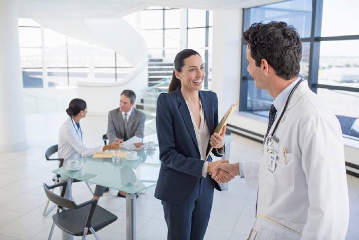 Doctor and business woman handshaking in meeting