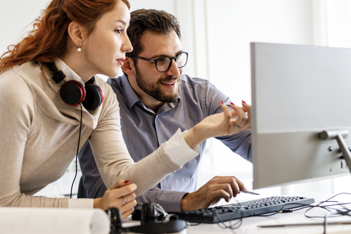 Office workers looking at computer screen