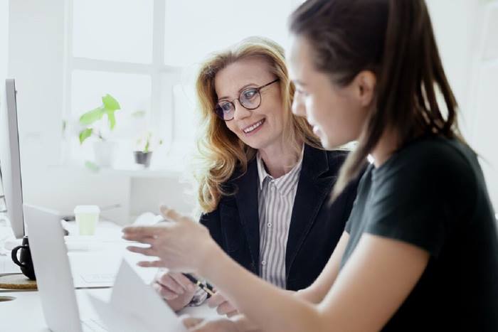 Women discussing project meeting at workplace
