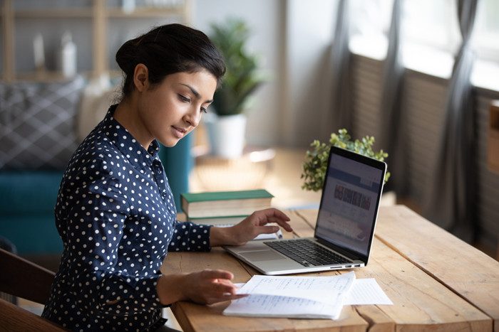 Girl at desk in living room studying on laptop