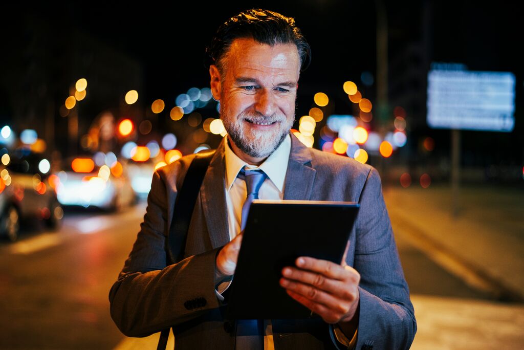 Mature business man using tablet at night