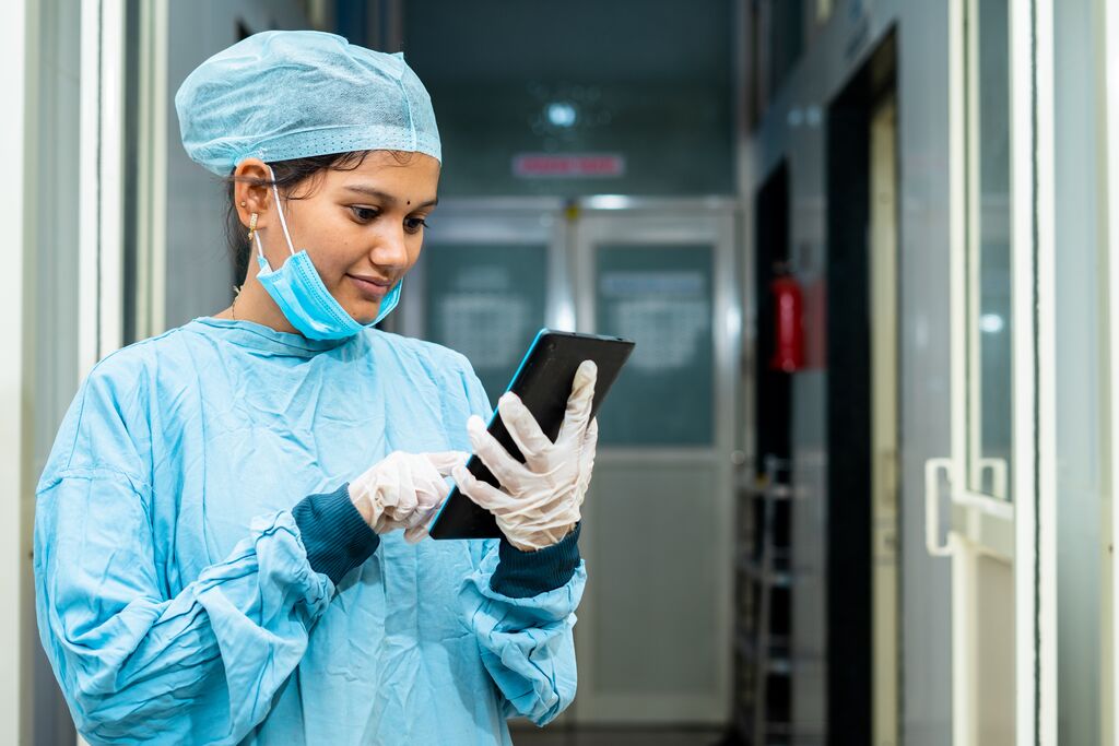 Surgeon using digital tablet at hospital corridor in India