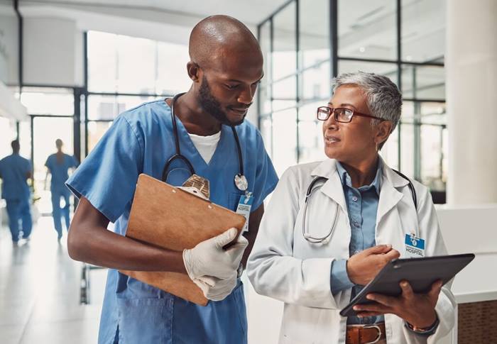 Doctor and nurse teamwork on tablet for hospital management in Africa