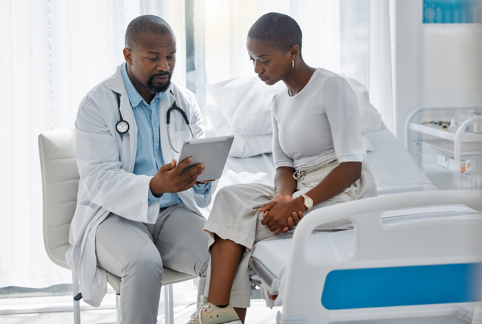 Doctor consulting patient with digital tablet in Africa