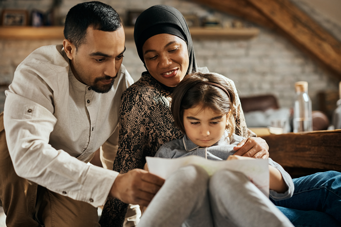 Smiling muslim family enjoys while drawing at home