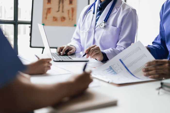 Team medical analysts and doctors consulting with graphs data and chart