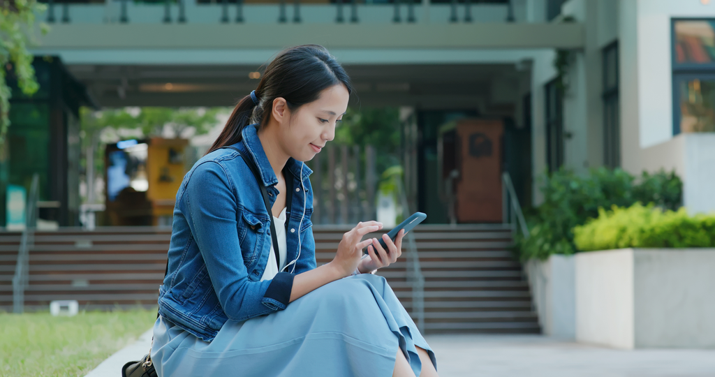 Woman hold with mobile phone in city