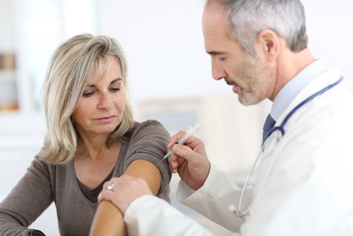 Doctor applying vaccine to woman