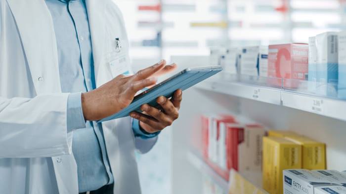 Pharmacist focus on hands with tablet