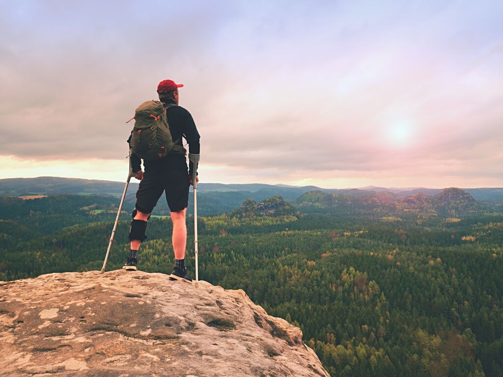 Man hiker Wearing Supportive Leg Brace and gainst the cruthes
