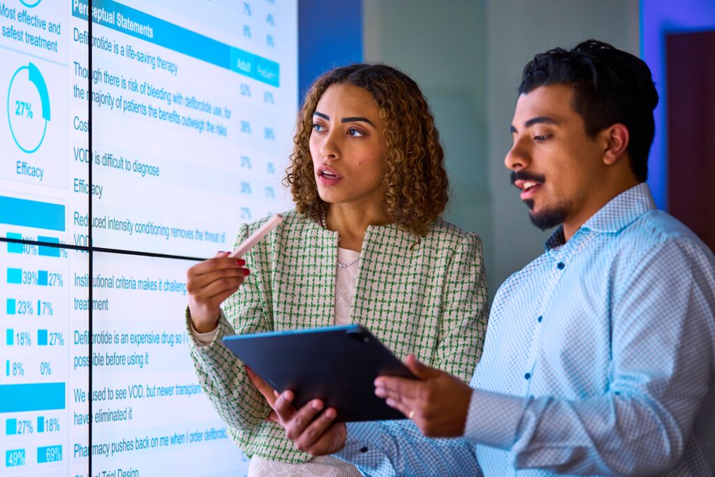 Custom Photo Two people looking at data on screens holding tablet