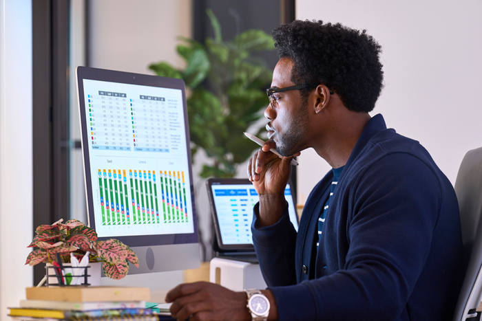 Custom Photo Male studying data on monitor