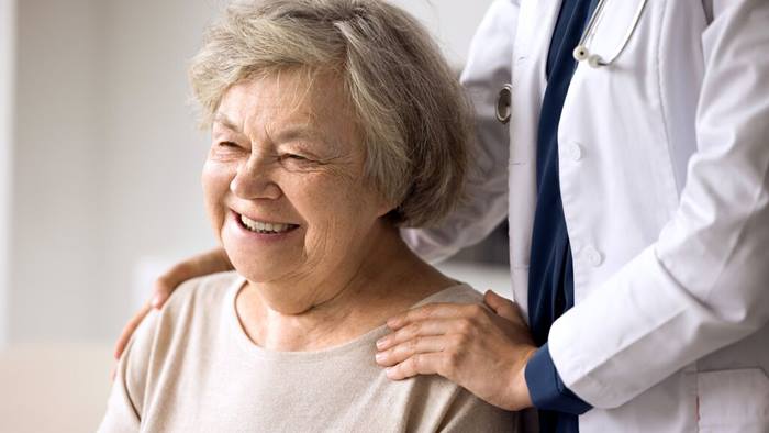 portrait of happy senior patient enjoying medical care in clinic