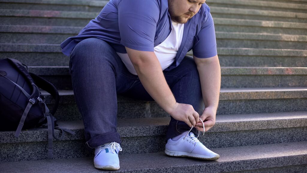 Plus size man tying shoelaces