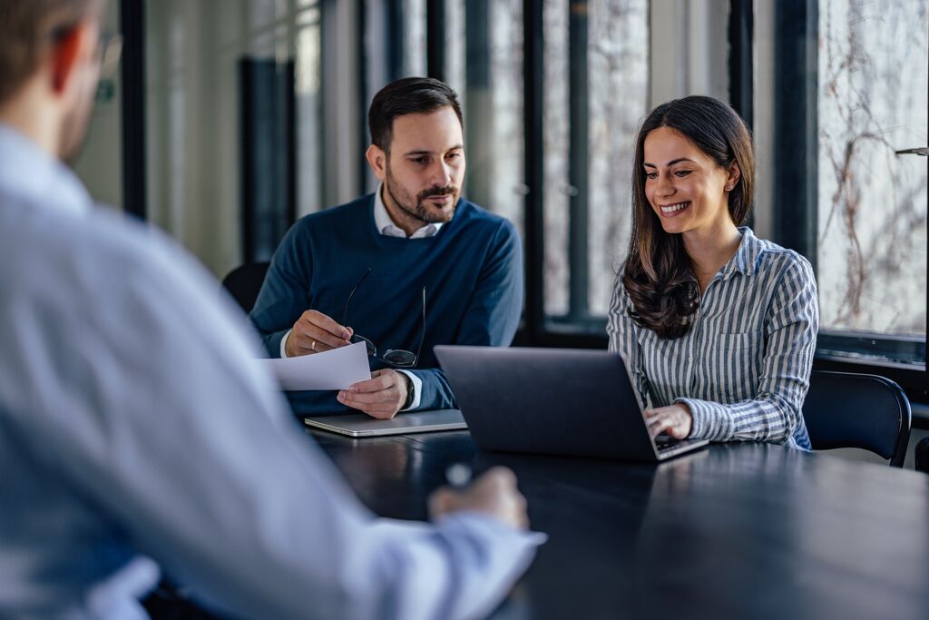 Focused man reviewing his colleagues screen during work session