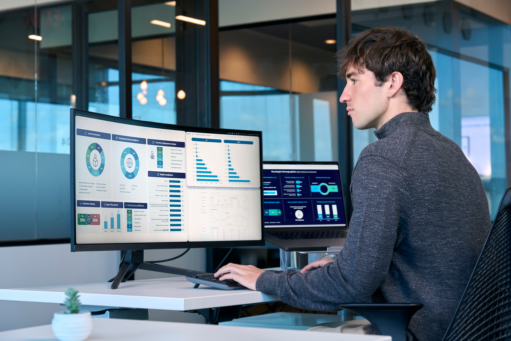 Male professional looking at graphs and charts on multiple
